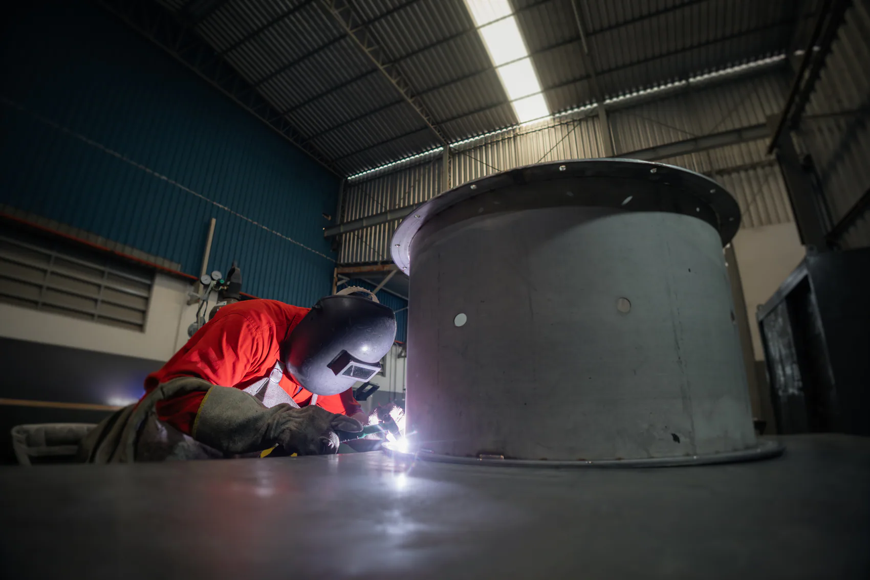 Profissional realizando soldagem em equipamento industrial